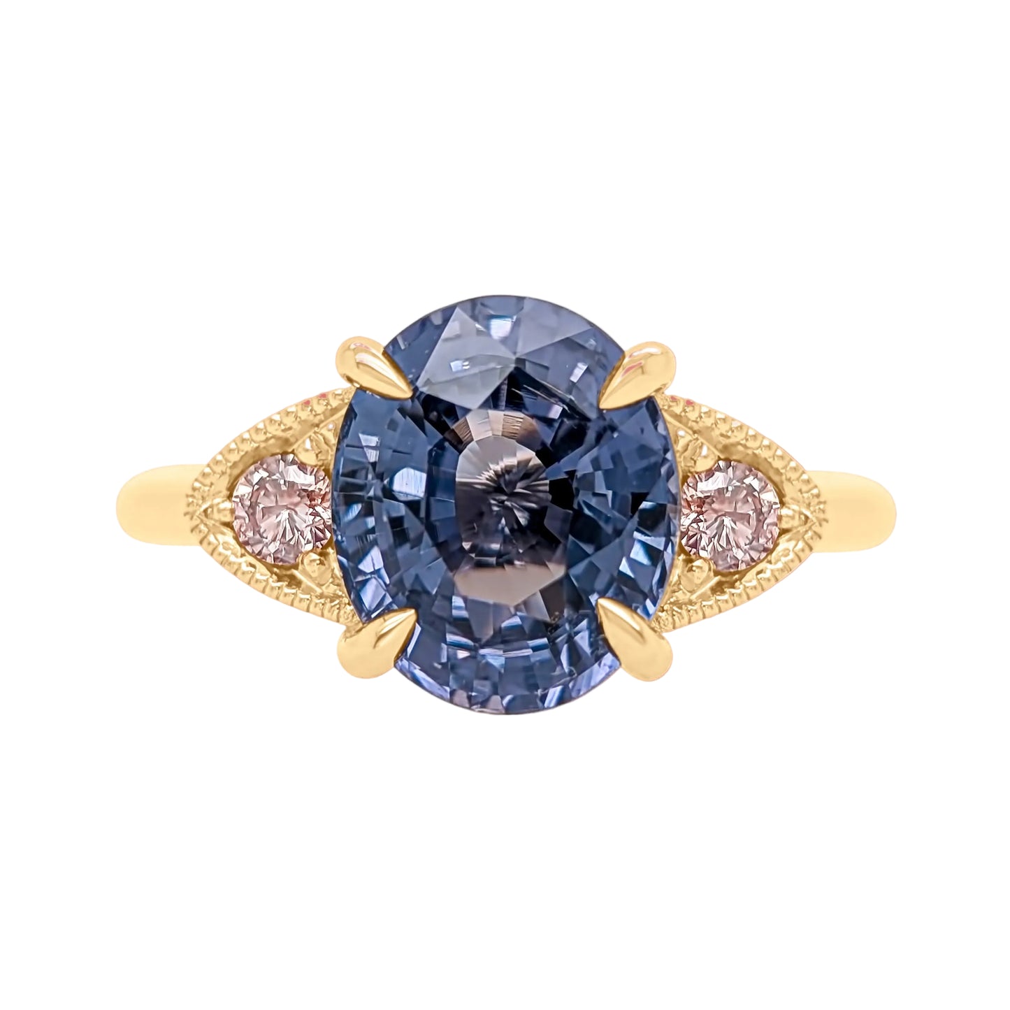 Gold ring with a blue gemstone and pink gemstones on a white background