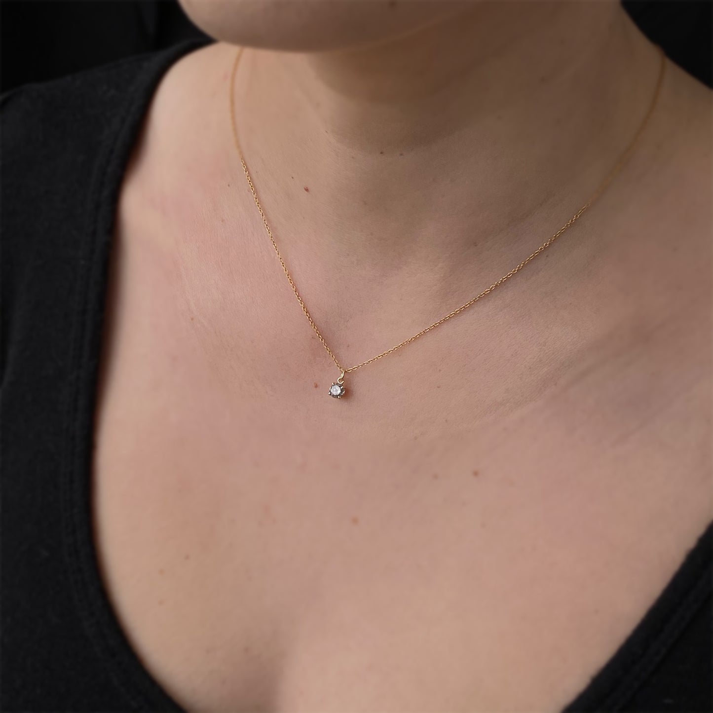 A sparkly and ethereal medium grey salt and pepper diamond in a dainty claw setting.