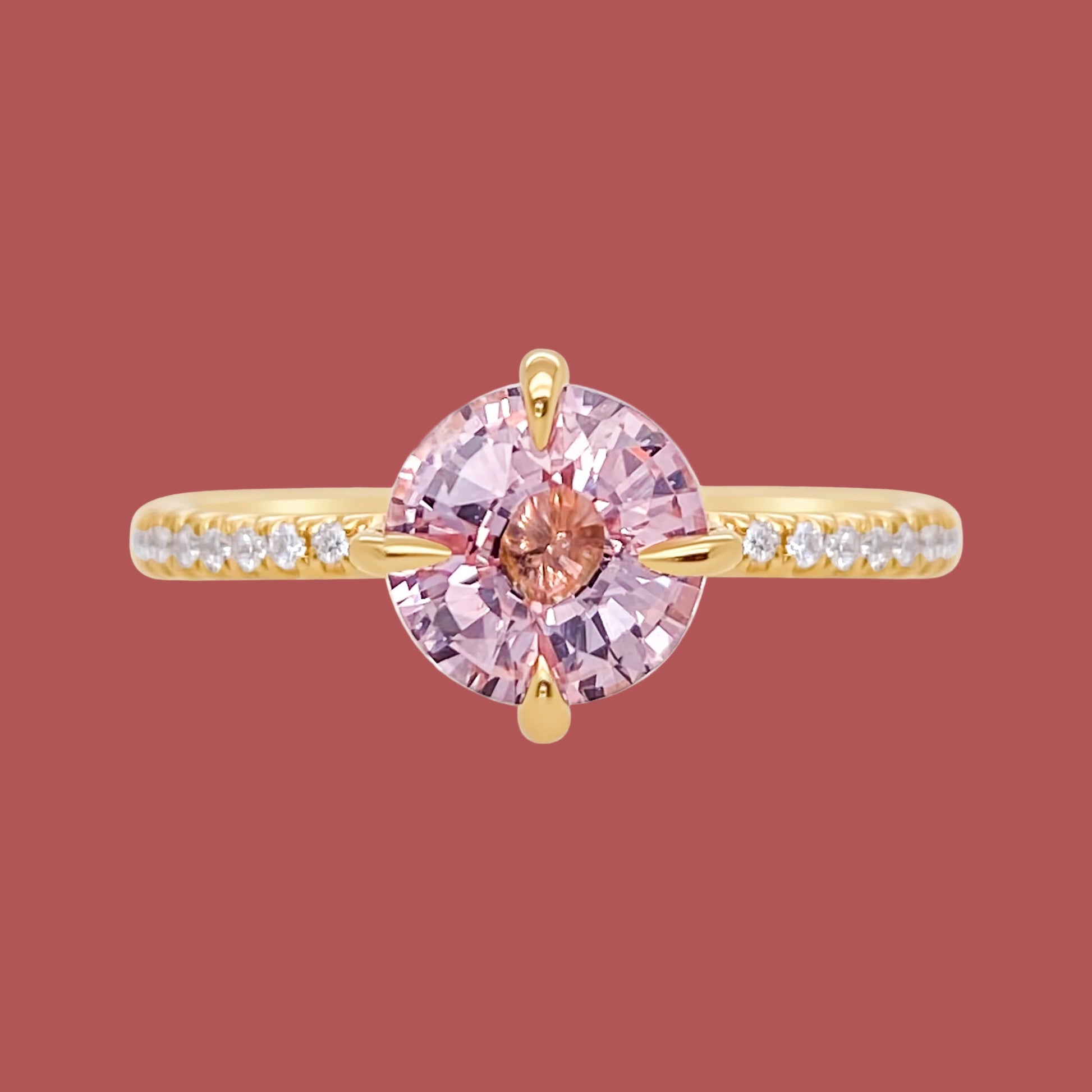 Gold ring with a pink gemstone on a white background