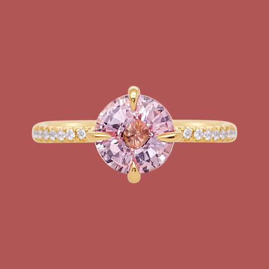 Gold ring with a pink gemstone on a white background