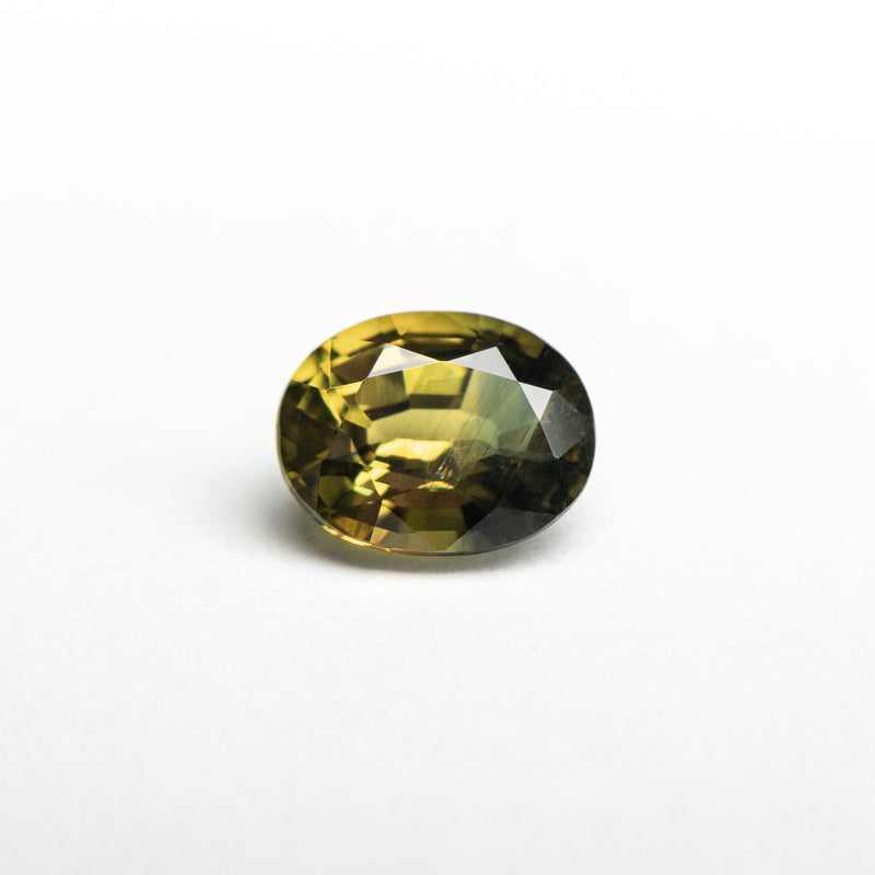 An oval brilliant cut sapphire with parti yellow-green color, originating from Australia.