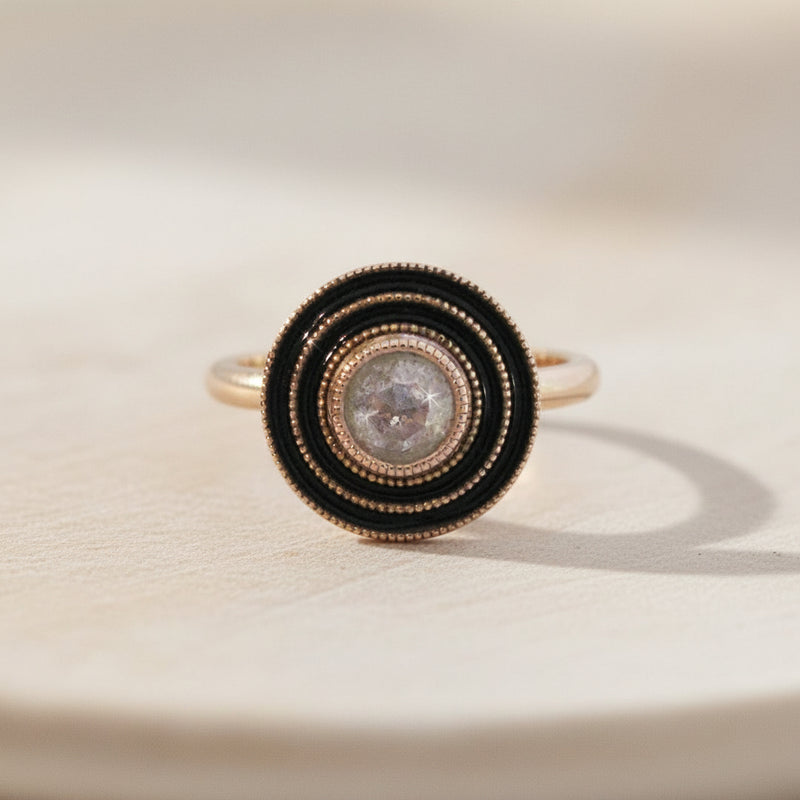 Ring with black and rose gold design on a white background
