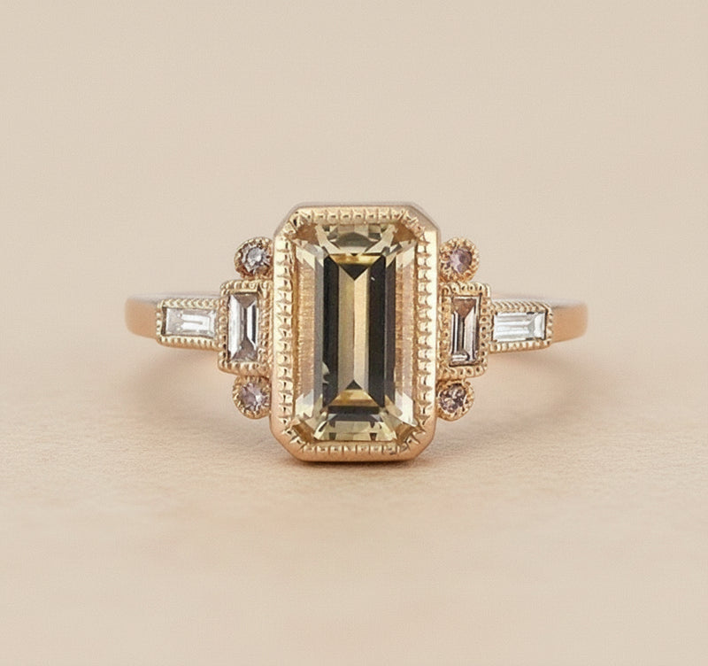 Gold ring with a central gemstone and smaller stones on a white background