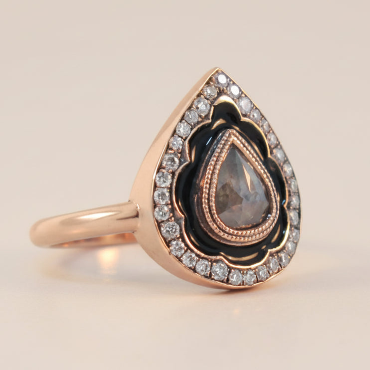 Rose gold ring with a teardrop-shaped gemstone and diamond accents 