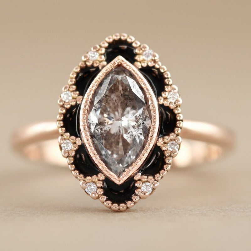 Rose gold ring with a large diamond and smaller diamonds on a light gray background