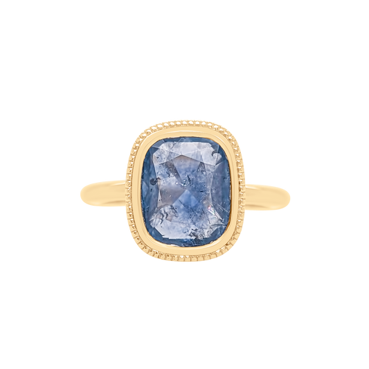 Gold ring with a blue gemstone on a white background