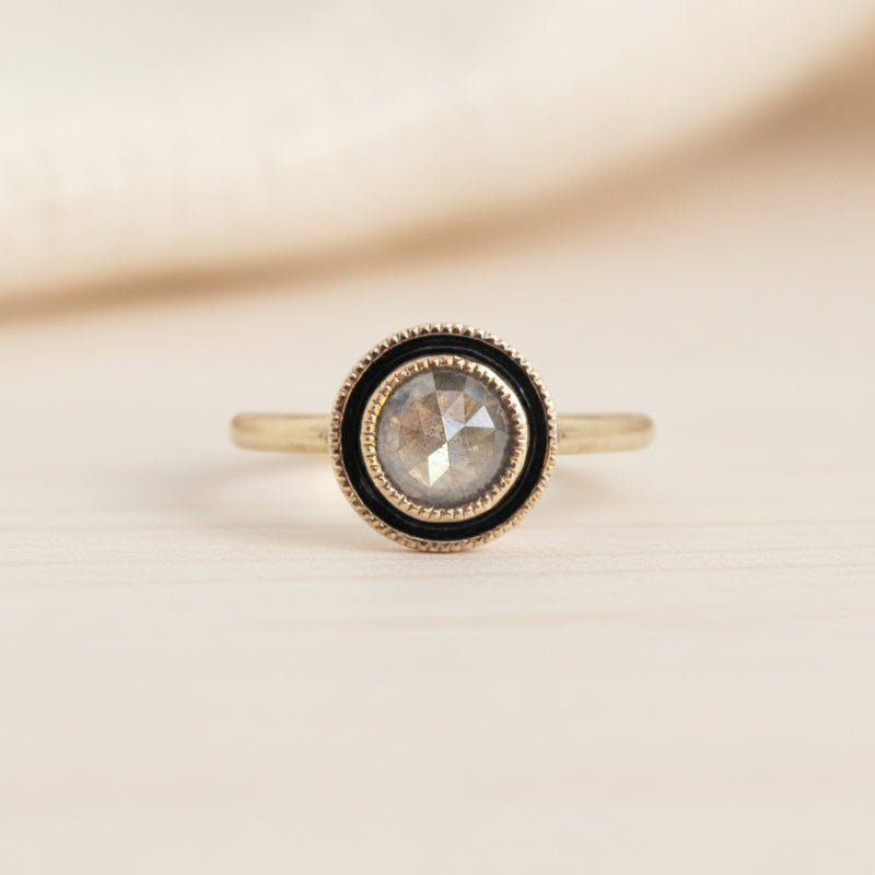 Gold ring with a central diamond gemstone on a white background