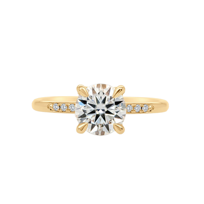 Gold ring with a large diamond and smaller diamonds on the band against a white background