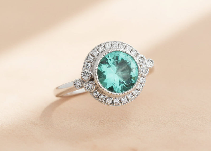 White gold emerald halo engagement ring