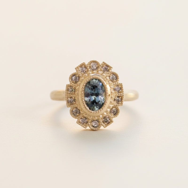 Gold ring with a blue gemstone on a white background