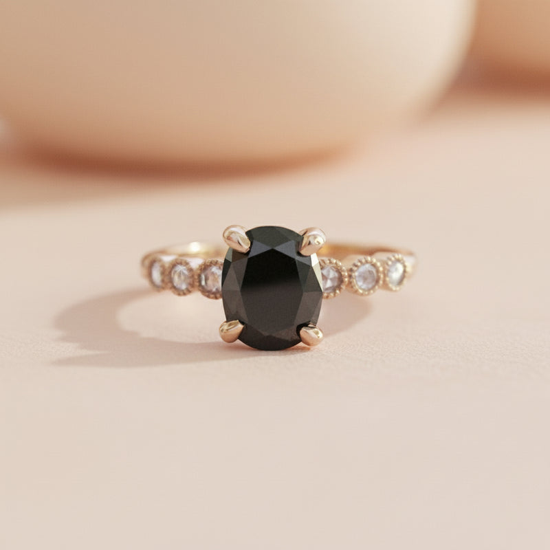 Ring with a black gemstone and rose gold band on a white background