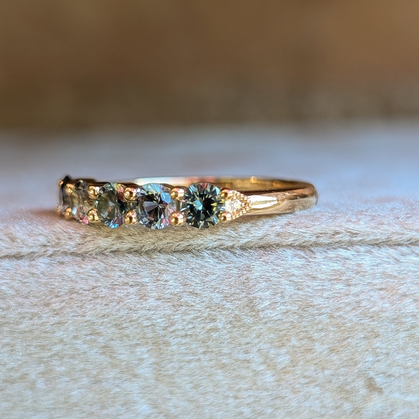 Gold ring with embedded stones on a textured surface