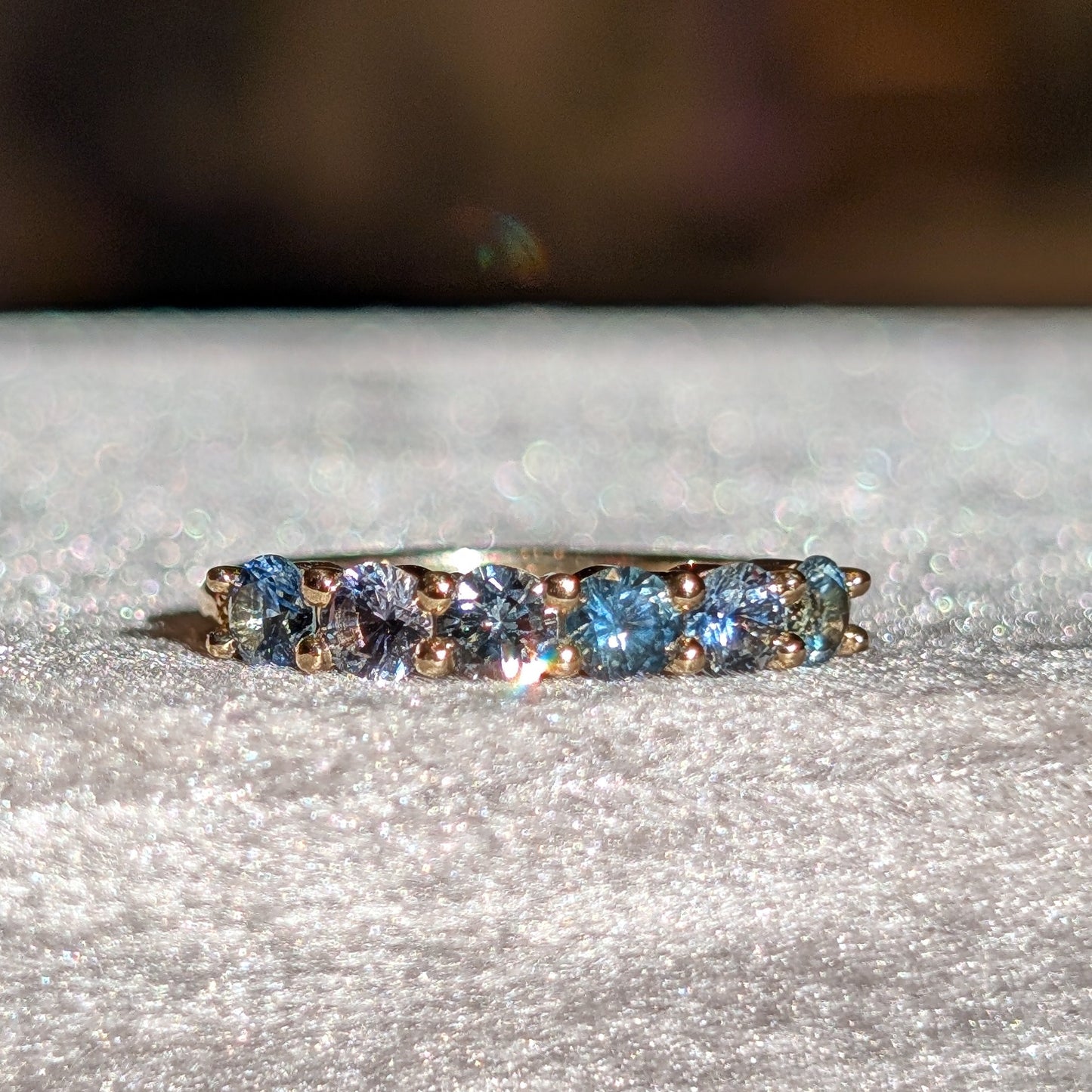 yellow gold ring with blue gemstones on a gray surface