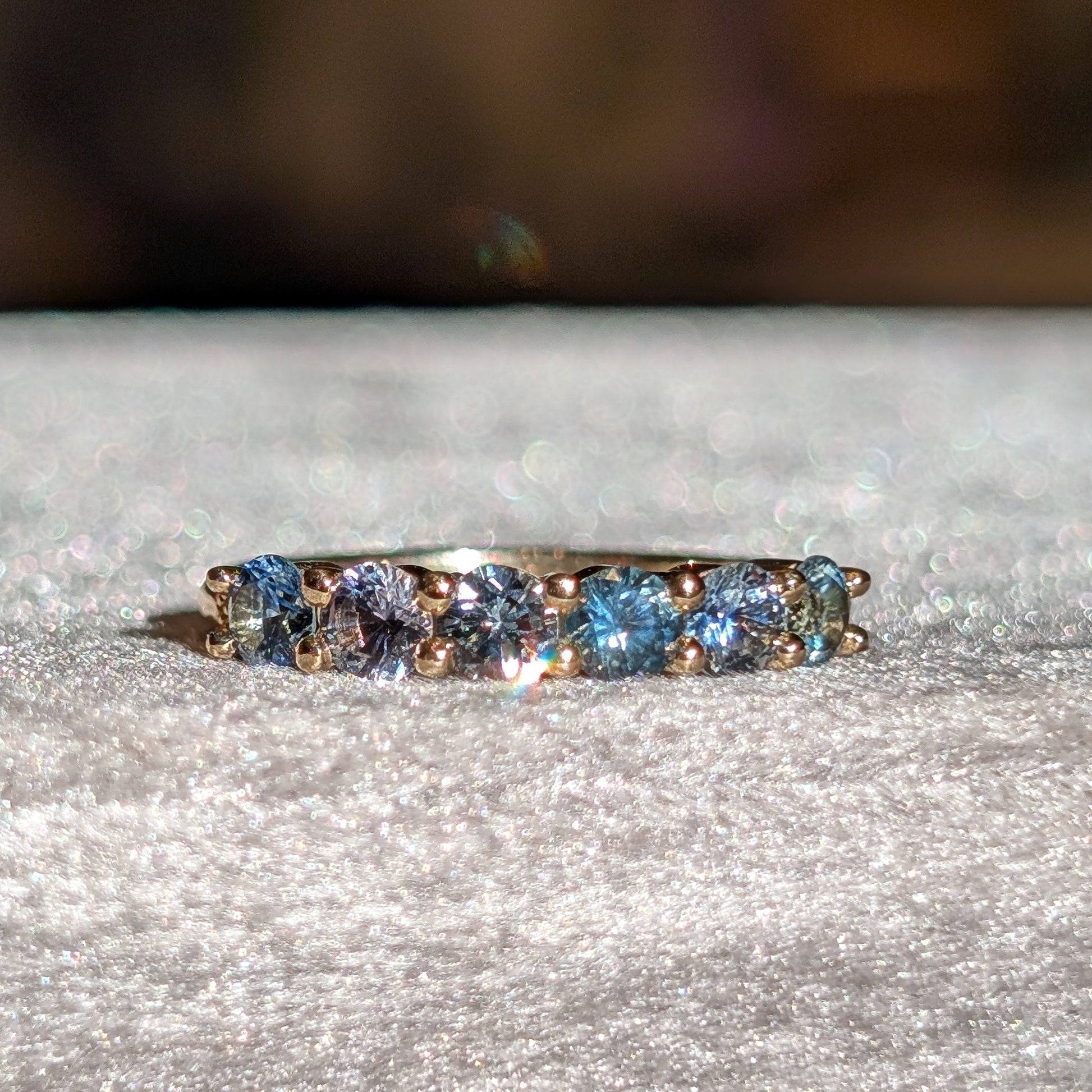 yellow gold ring with blue gemstones on a gray surface