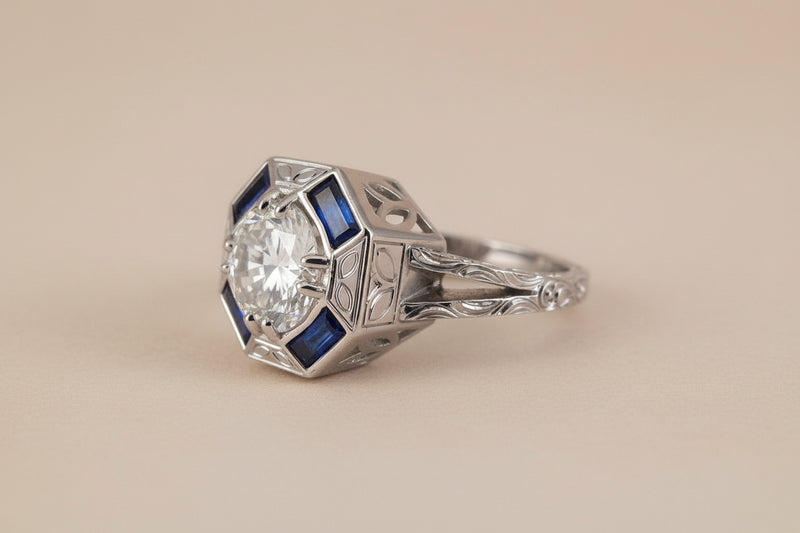Platinum ring with a large diamond and blue gemstones on a white background