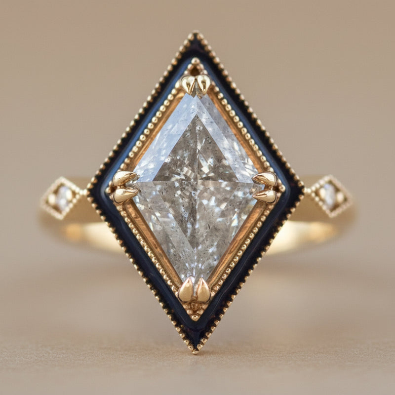 Gold ring with a large kite diamond and smaller diamonds on a light gray background