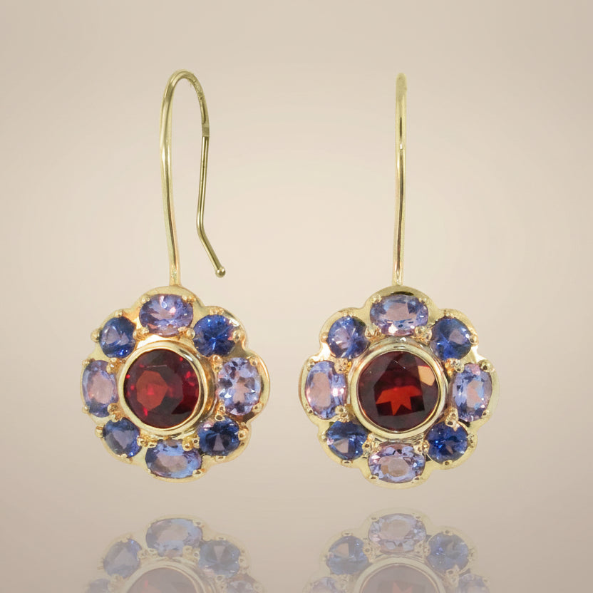 A pair of gold-colored bouquet earrings featuring a floral pattern with blue, red, and purple gemstones.
